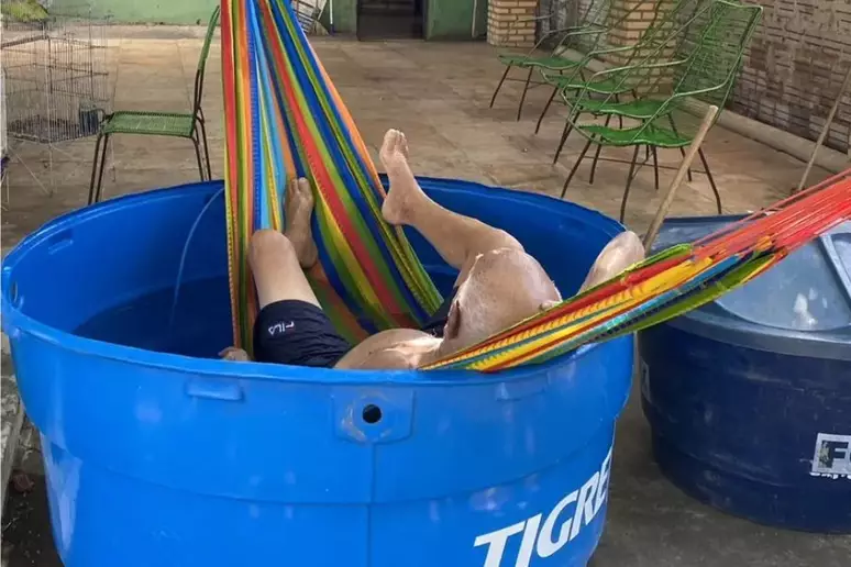 Idoso tenta fugir do calorão com rede dentro de caixa d’água e viraliza nas redes sociais
